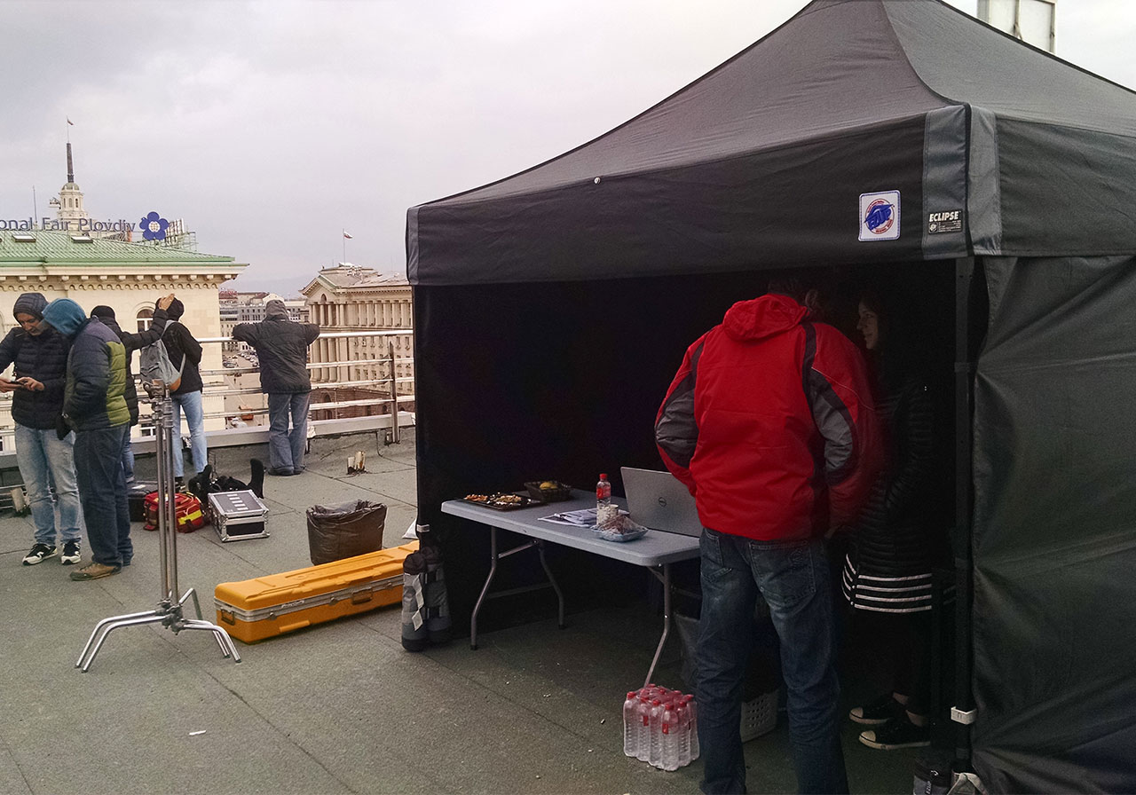 Плътна черна шатра E-Z UP® на снимачна площадка на покрив в центъра на София